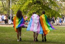 people wearing rainbow capes
